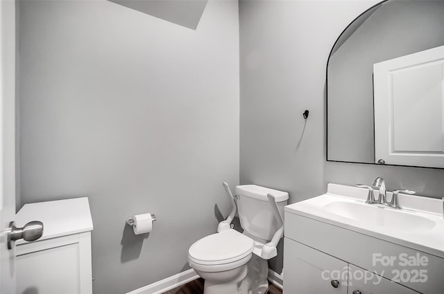 bathroom featuring toilet, hardwood / wood-style flooring, and vanity