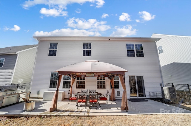 back of property featuring a patio area and a gazebo