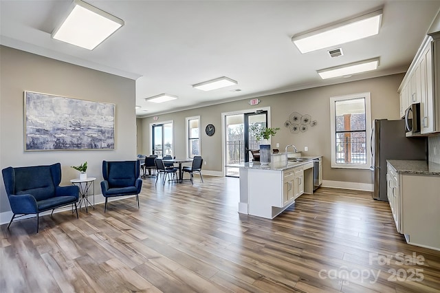 kitchen with white cabinets, stainless steel appliances, and light stone countertops