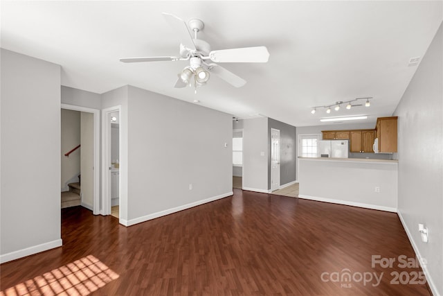 unfurnished living room featuring ceiling fan and dark hardwood / wood-style flooring