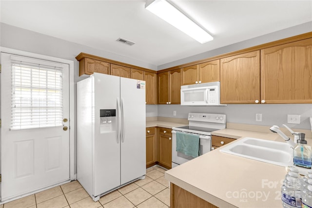 kitchen featuring sink, light tile patterned flooring, and white appliances