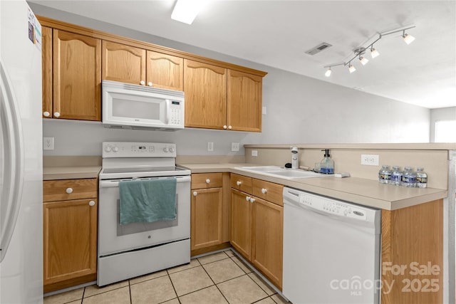 kitchen with white appliances, sink, and light tile patterned floors