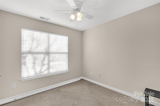 carpeted spare room with ceiling fan