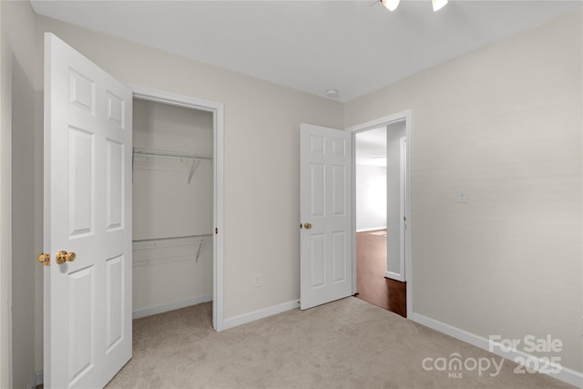 unfurnished bedroom featuring light carpet and a closet