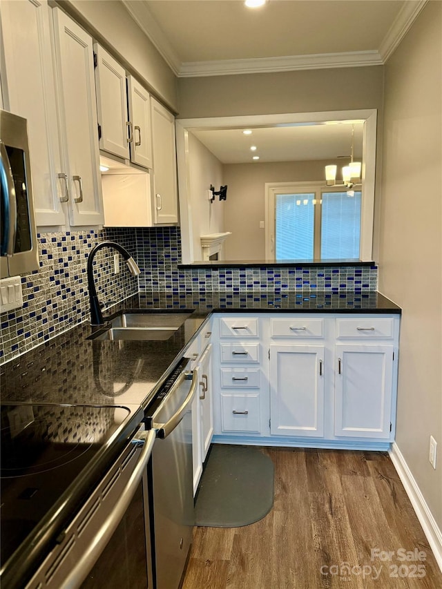 kitchen with white cabinetry, light hardwood / wood-style floors, appliances with stainless steel finishes, ornamental molding, and sink