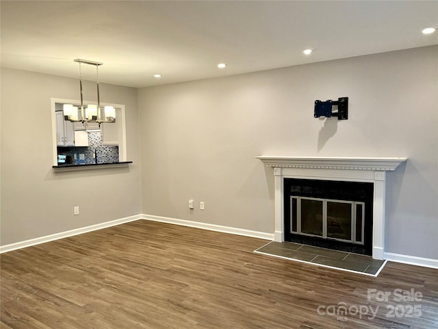 unfurnished living room featuring dark hardwood / wood-style floors, a chandelier, and a fireplace