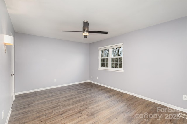 empty room featuring ceiling fan and dark wood-type flooring