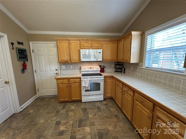 kitchen featuring white appliances, tile counters, crown molding, and backsplash