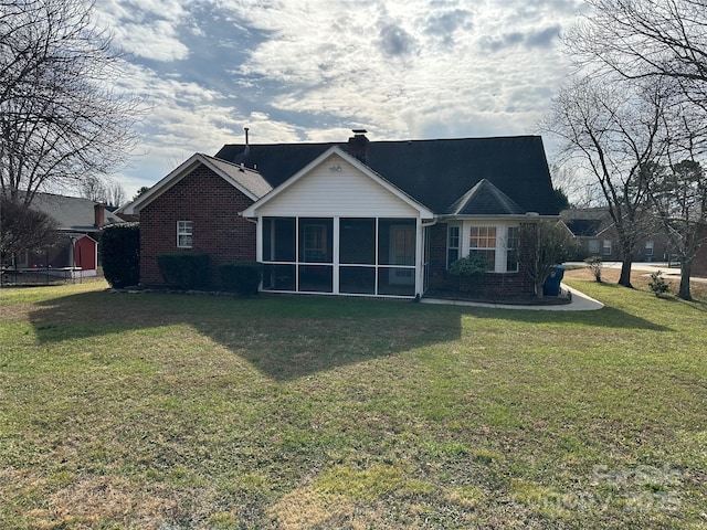 rear view of property featuring a sunroom and a lawn