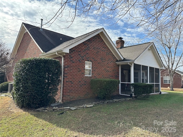 view of side of property with a lawn and a sunroom