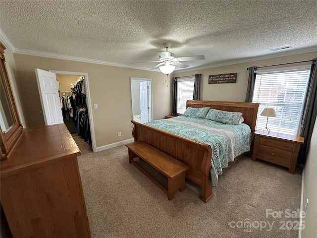 carpeted bedroom featuring a walk in closet, crown molding, ceiling fan, multiple windows, and a closet