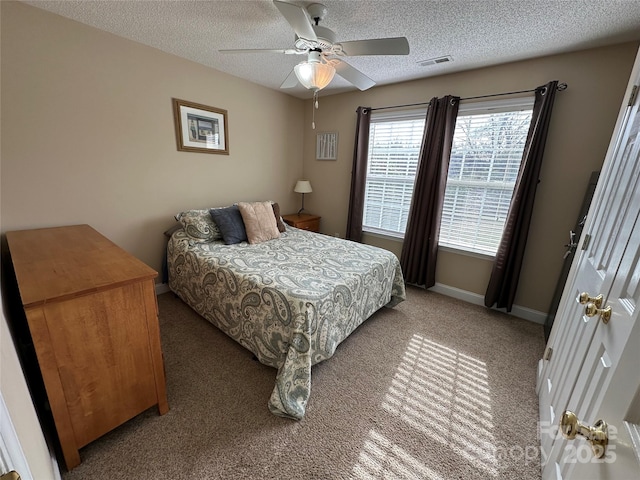 carpeted bedroom with ceiling fan and a textured ceiling