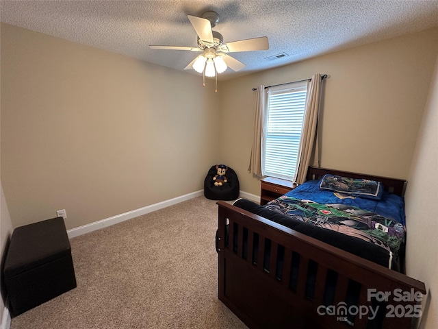 bedroom featuring ceiling fan, carpet floors, and a textured ceiling