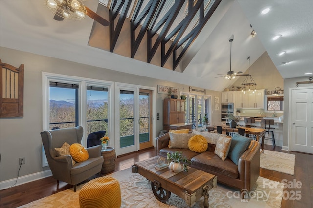 living room with hardwood / wood-style flooring, high vaulted ceiling, ceiling fan, and a healthy amount of sunlight