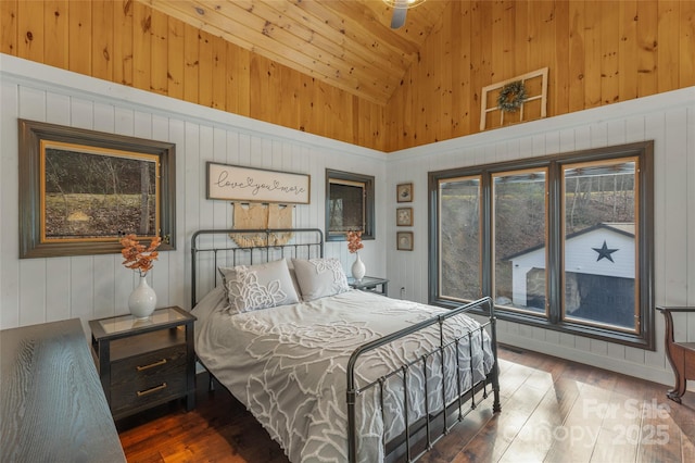 bedroom with dark hardwood / wood-style flooring, wood ceiling, ceiling fan, wooden walls, and high vaulted ceiling