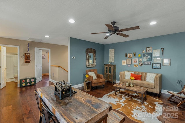 living room with ceiling fan and dark hardwood / wood-style flooring