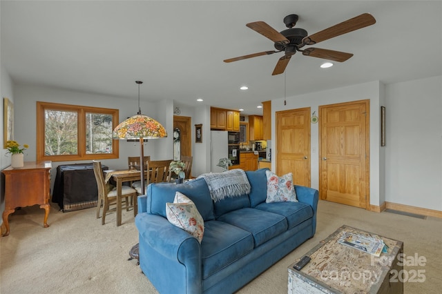 carpeted living room featuring ceiling fan