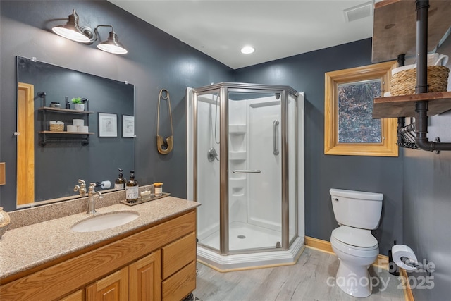 bathroom featuring hardwood / wood-style floors, vanity, toilet, and walk in shower