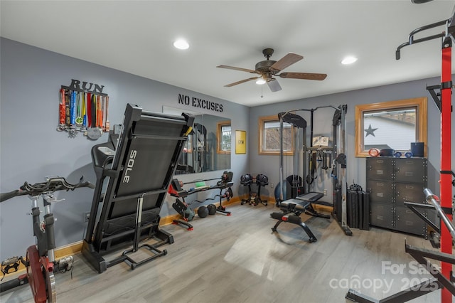 exercise room with ceiling fan and light hardwood / wood-style flooring