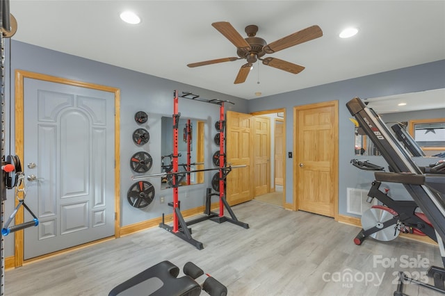 workout area featuring light wood-type flooring and ceiling fan