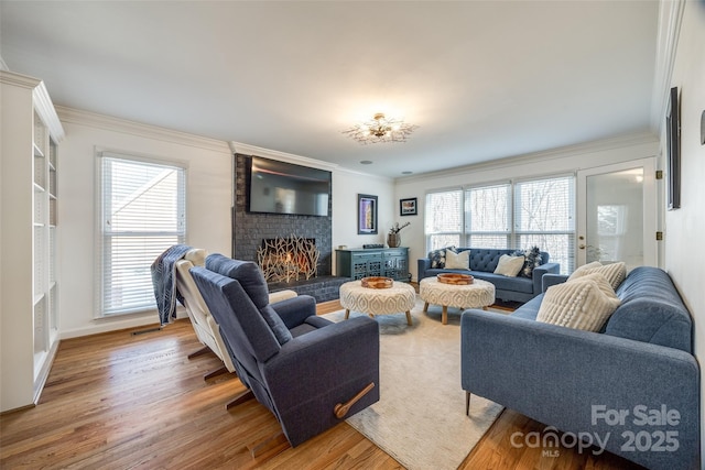 living room featuring a brick fireplace, hardwood / wood-style floors, a wealth of natural light, and ornamental molding