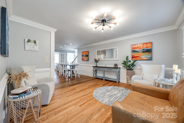 living room with wood-type flooring, a chandelier, and crown molding