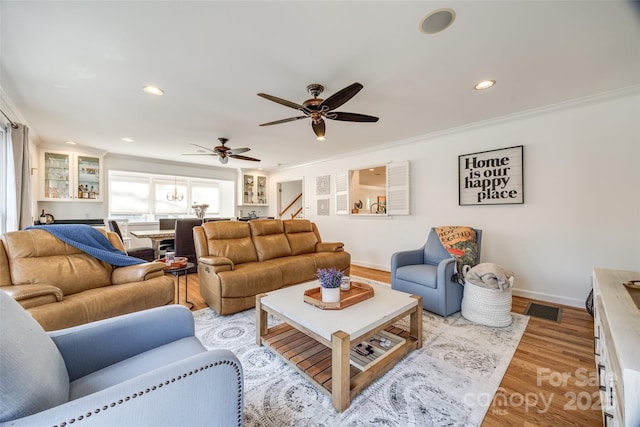 living room featuring ceiling fan, light hardwood / wood-style floors, and ornamental molding