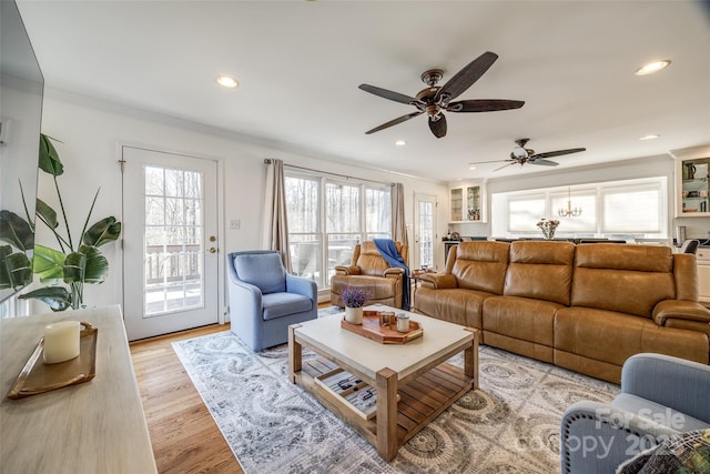 living room featuring ceiling fan, ornamental molding, and light hardwood / wood-style floors