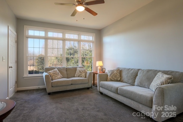 living room featuring dark colored carpet and ceiling fan