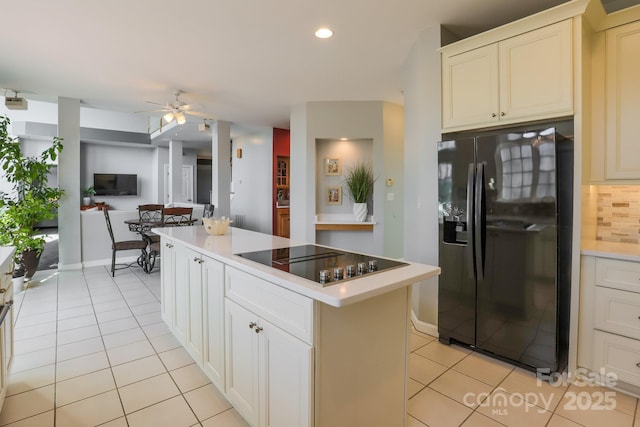 kitchen with tasteful backsplash, a center island, light tile patterned floors, ceiling fan, and black appliances