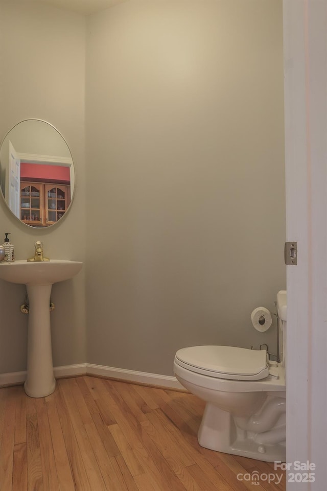 bathroom featuring hardwood / wood-style flooring and toilet