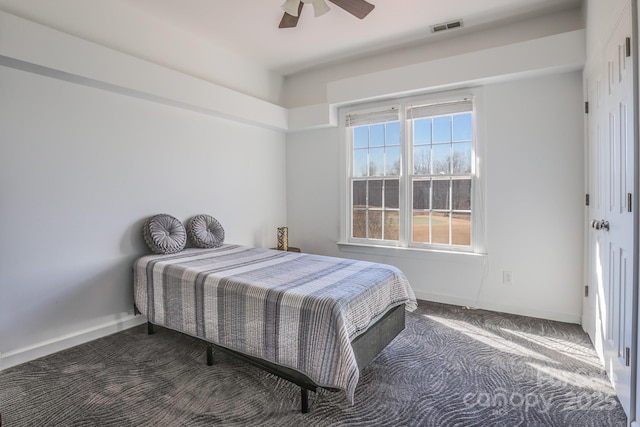 bedroom featuring ceiling fan and dark carpet