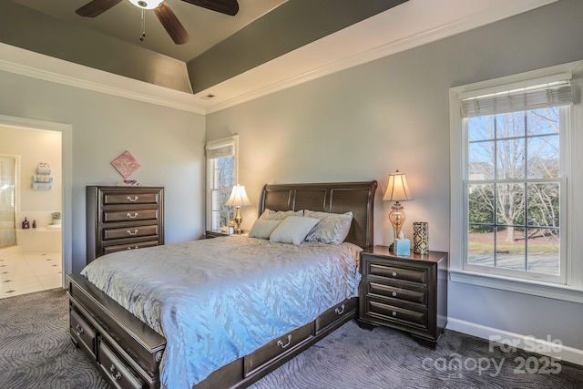 carpeted bedroom with ornamental molding, a tray ceiling, connected bathroom, and multiple windows