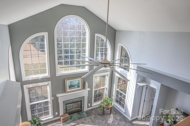 carpeted living room with a fireplace, high vaulted ceiling, and plenty of natural light