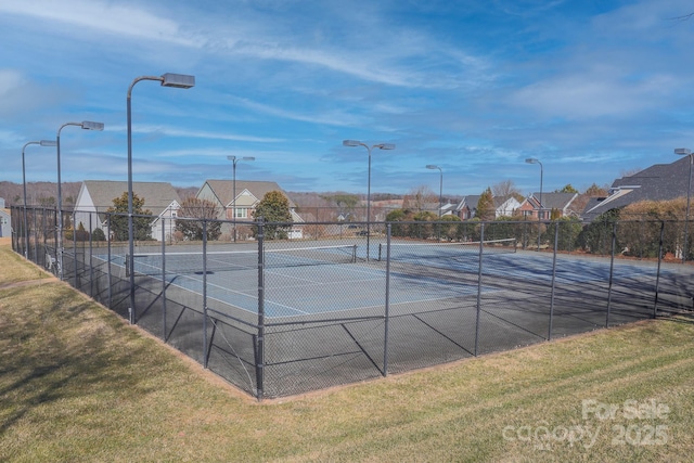 view of sport court with a lawn