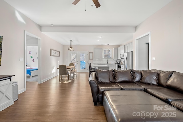 living room featuring ceiling fan, wood-type flooring, french doors, and sink