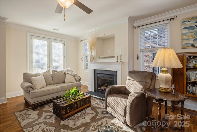 living room featuring ceiling fan, ornamental molding, and dark hardwood / wood-style flooring