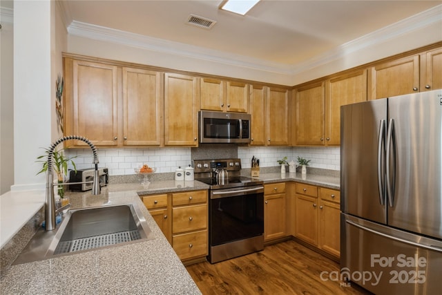 kitchen with dark wood-type flooring, appliances with stainless steel finishes, backsplash, and sink