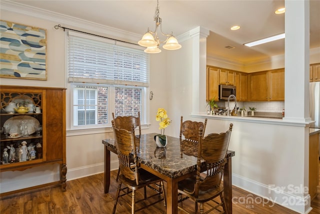 dining area with dark wood-type flooring, a chandelier, and crown molding