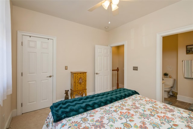 bedroom with ceiling fan, light carpet, and connected bathroom