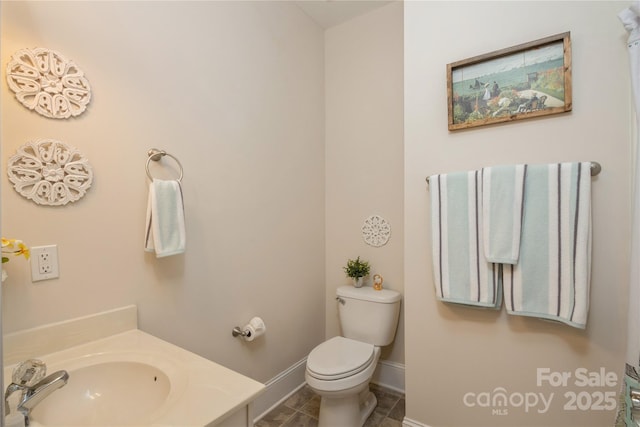 bathroom with toilet, tile patterned floors, and sink