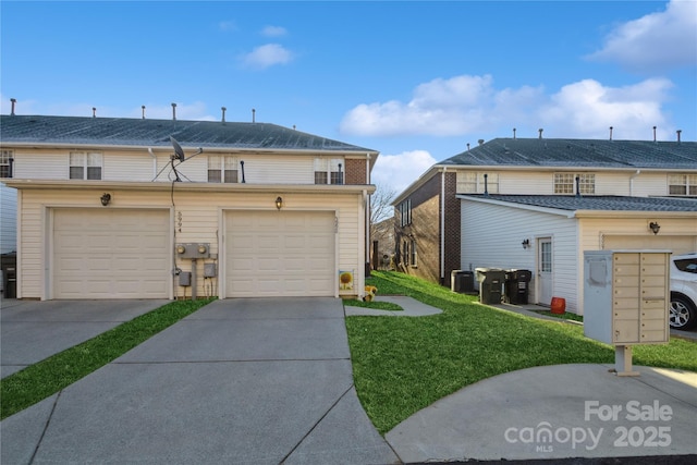 view of front of home featuring a garage, a front lawn, and central AC