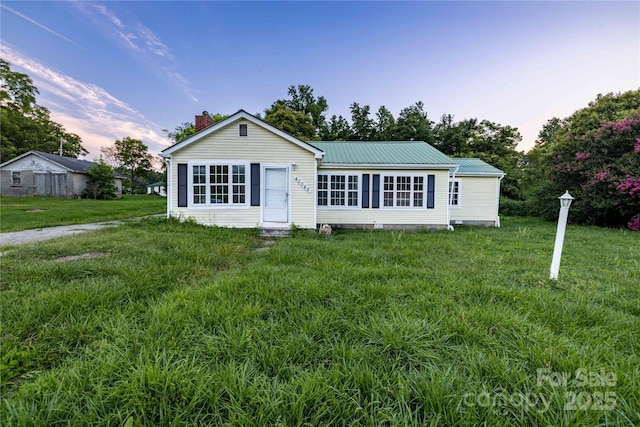 single story home featuring a lawn