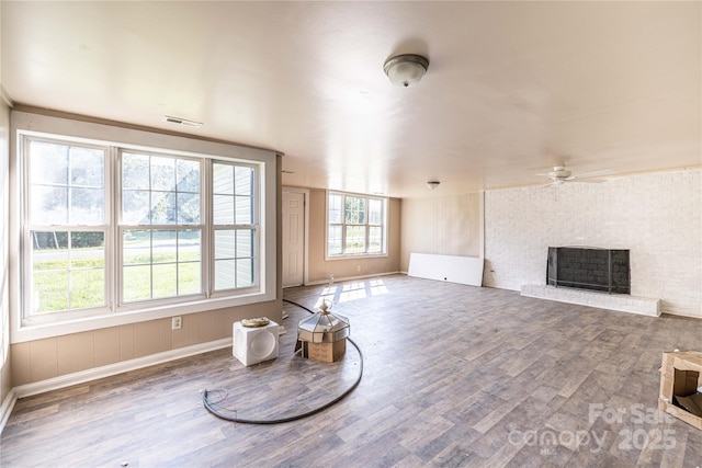 living room featuring ceiling fan, a fireplace, and hardwood / wood-style floors