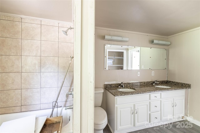 full bathroom with hardwood / wood-style flooring, vanity, tub / shower combination, and toilet