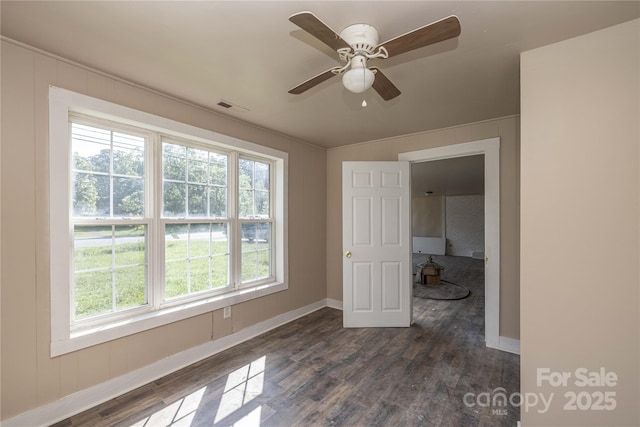 unfurnished room with ceiling fan and dark wood-type flooring