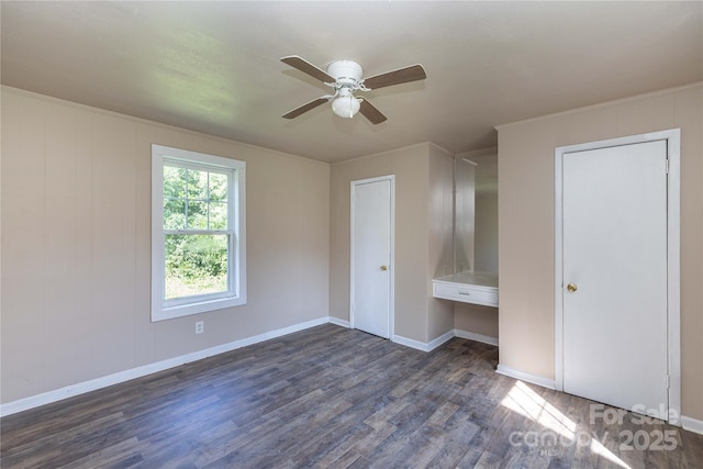 unfurnished bedroom with dark hardwood / wood-style flooring, ceiling fan, and built in desk