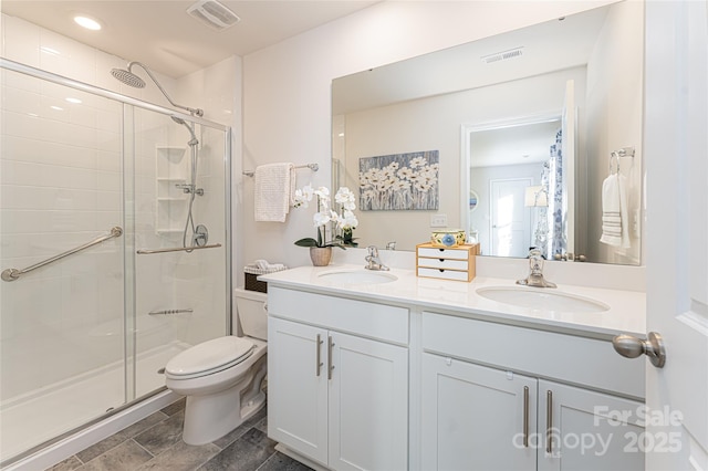 bathroom featuring toilet, an enclosed shower, and vanity