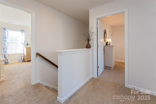 hall with light colored carpet