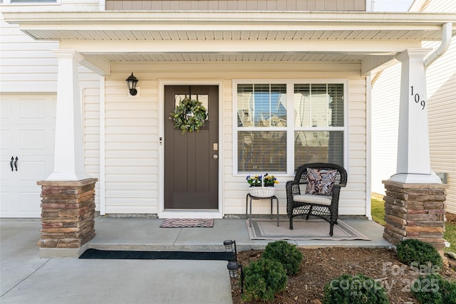 doorway to property with a porch and concrete driveway